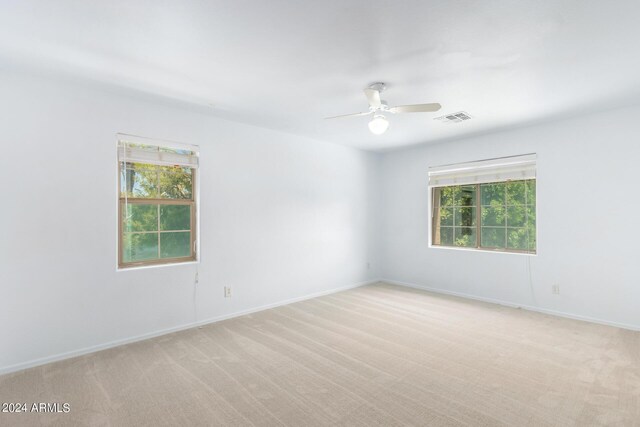 carpeted spare room featuring ceiling fan