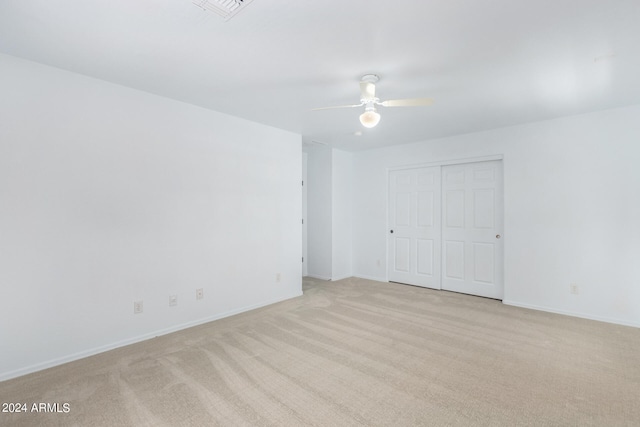 empty room featuring light colored carpet and ceiling fan