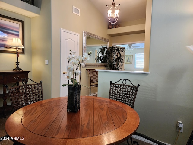 dining space with ceiling fan with notable chandelier and vaulted ceiling