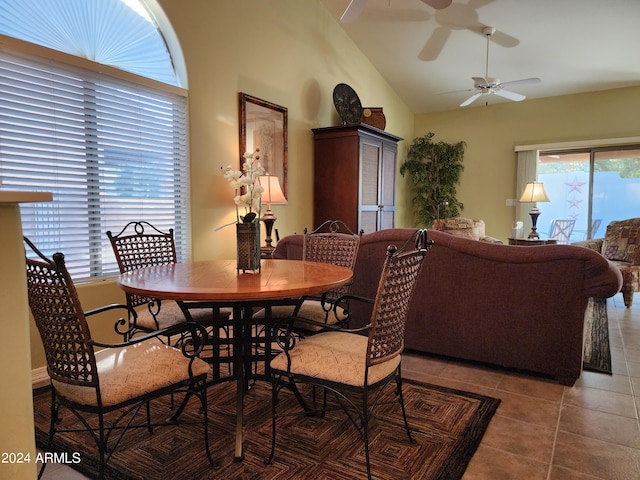 dining room with ceiling fan, vaulted ceiling, and light tile patterned flooring