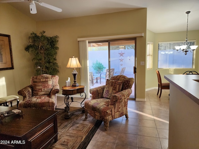 living area featuring ceiling fan with notable chandelier and tile patterned flooring