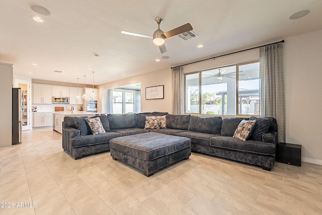 living area with recessed lighting, visible vents, and ceiling fan