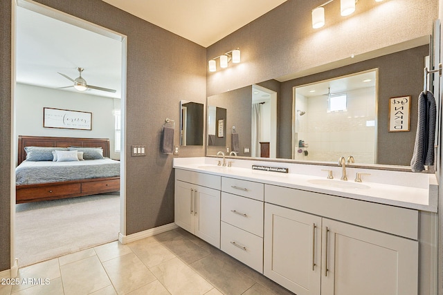 full bath with tiled shower, a sink, a ceiling fan, and connected bathroom