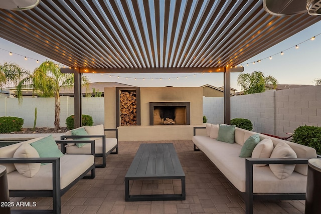 view of patio with a fenced backyard, an outdoor living space with a fireplace, and a pergola