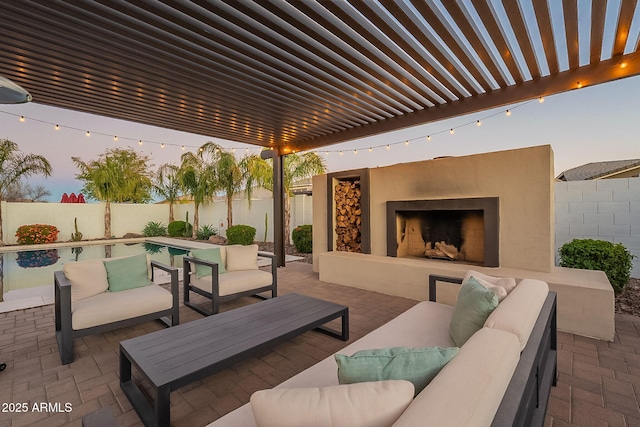 patio terrace at dusk with a fenced in pool, a pergola, a fenced backyard, and an outdoor living space with a fireplace