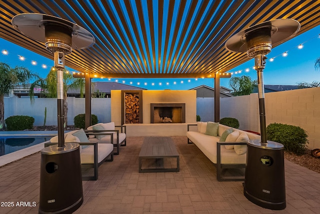 view of patio / terrace with a fenced backyard and an outdoor living space with a fireplace