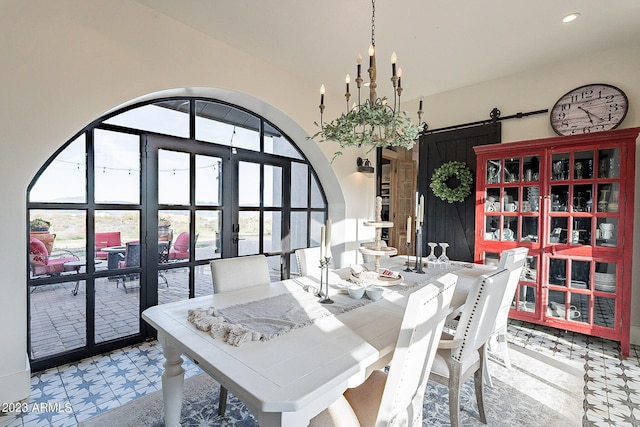 tiled dining room with a barn door and french doors