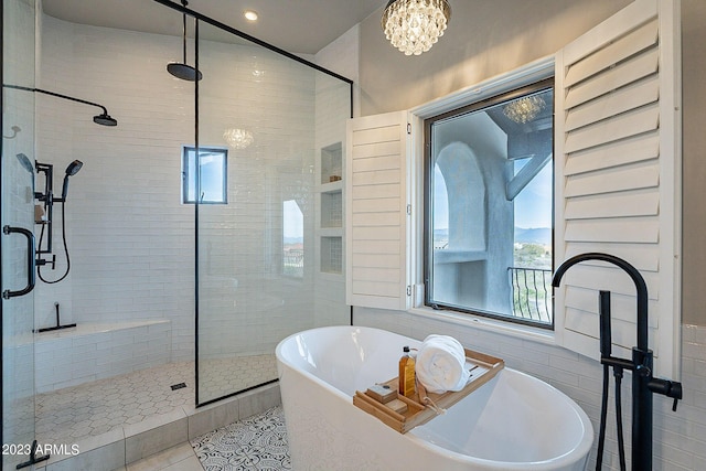 bathroom with tile patterned flooring, independent shower and bath, and a notable chandelier