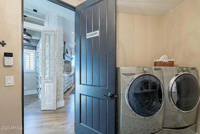 washroom with washer and dryer and light hardwood / wood-style floors