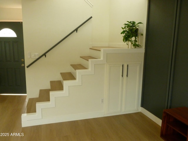 staircase with baseboards and wood finished floors