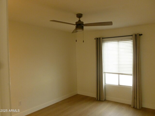 empty room featuring ceiling fan, baseboards, and light wood-style floors