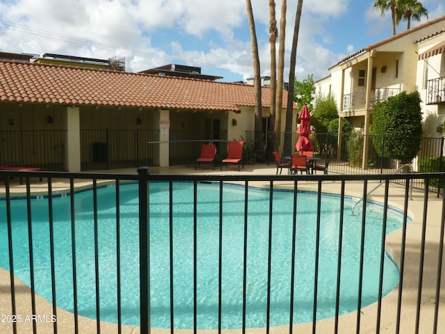 pool featuring a patio area and fence