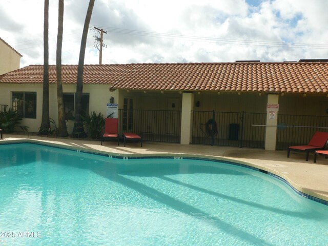 community pool featuring a patio and fence