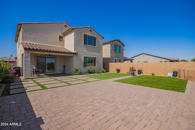 rear view of property with a yard and a patio area