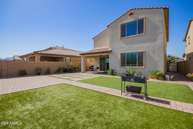 back of property with a yard and a patio area