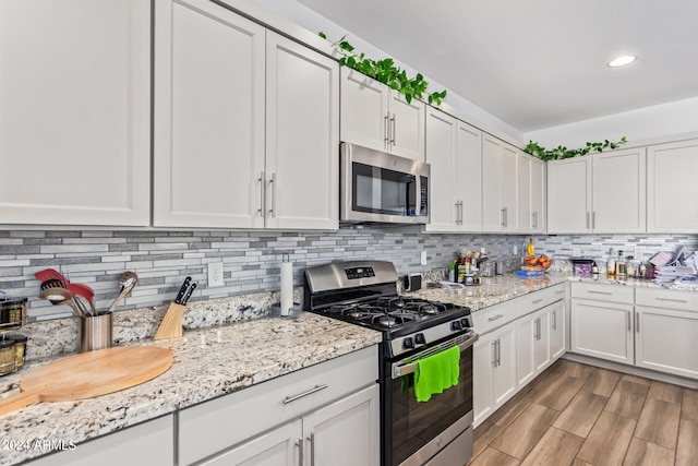 kitchen featuring tasteful backsplash, white cabinetry, and appliances with stainless steel finishes