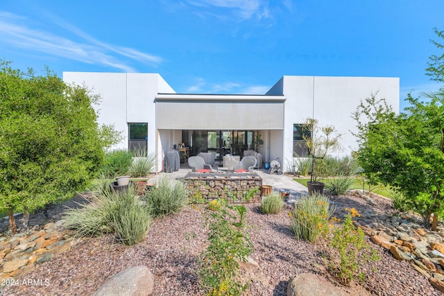 rear view of property featuring an outdoor living space and a patio