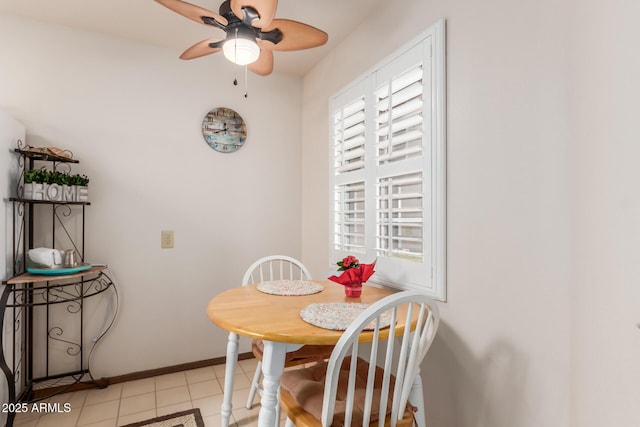 dining room with ceiling fan, baseboards, and light tile patterned flooring