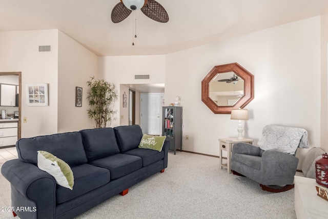 living area featuring baseboards, a ceiling fan, visible vents, and light colored carpet