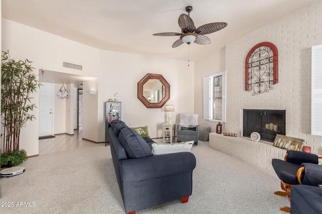 living room featuring a brick fireplace, carpet, visible vents, and ceiling fan