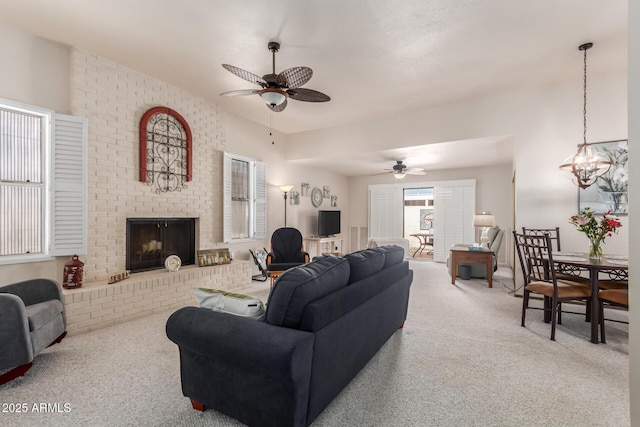 living room with carpet floors, a brick fireplace, and a ceiling fan