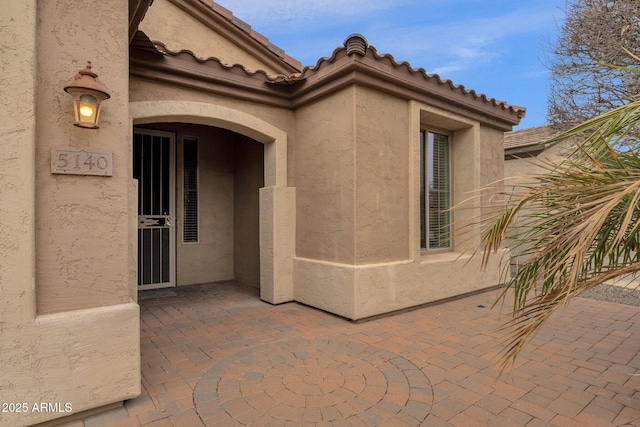 view of exterior entry with a patio