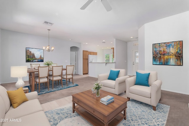 living room with ceiling fan with notable chandelier