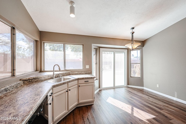 kitchen with sink, a textured ceiling, dark hardwood / wood-style flooring, pendant lighting, and white cabinets