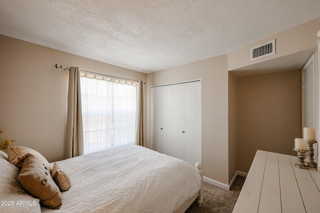 bedroom featuring a closet, a textured ceiling, and carpet flooring