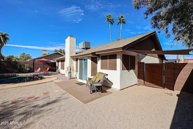 back of property featuring a fenced in pool, a patio area, and central air condition unit