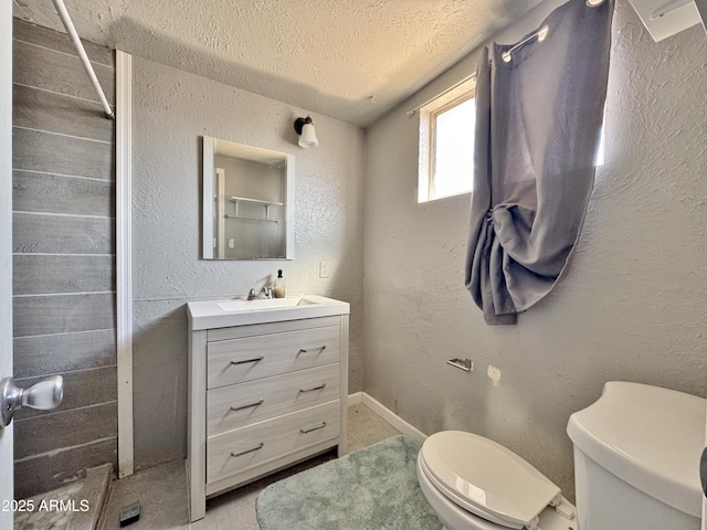 bathroom featuring vanity, toilet, and a textured ceiling