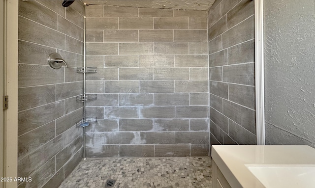 bathroom with sink and a tile shower