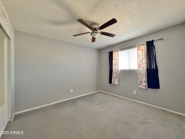 carpeted spare room featuring ceiling fan and a textured ceiling