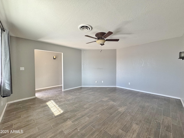 unfurnished room with a textured ceiling, dark wood-type flooring, and ceiling fan