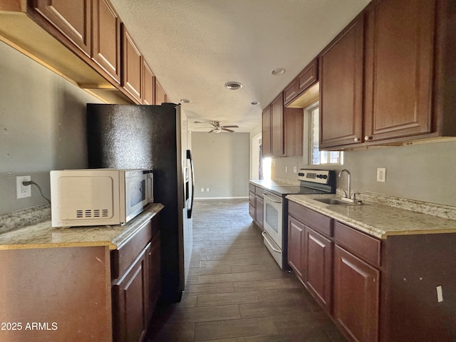 kitchen featuring electric stove, sink, ceiling fan, dark hardwood / wood-style floors, and a textured ceiling