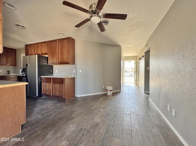 kitchen featuring a textured ceiling, ceiling fan, and stainless steel fridge with ice dispenser