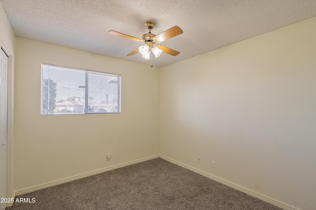 unfurnished room with ceiling fan, a textured ceiling, and dark colored carpet