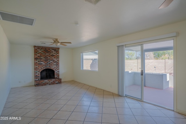 unfurnished living room featuring ceiling fan, light tile patterned floors, and a fireplace