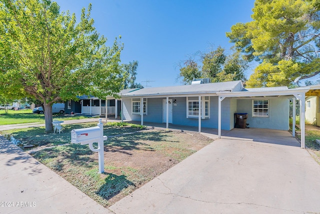 single story home featuring a carport, covered porch, and a front yard