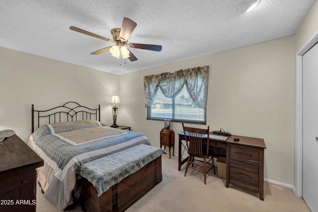 bedroom with light colored carpet, ceiling fan, and a textured ceiling