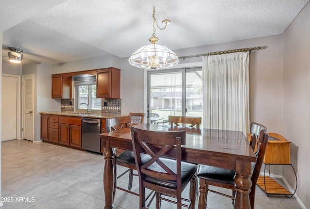 dining space with baseboards, a textured ceiling, and an inviting chandelier