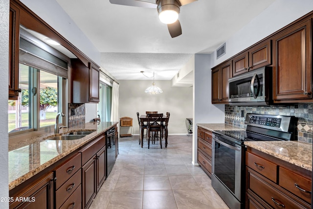 kitchen with visible vents, a sink, tasteful backsplash, stainless steel appliances, and ceiling fan