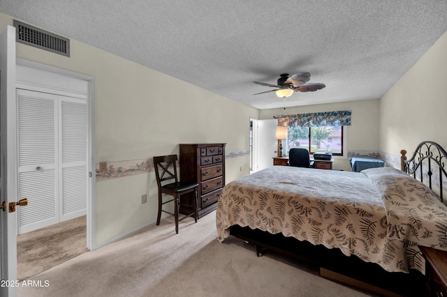 bedroom featuring visible vents, carpet, a ceiling fan, and a textured ceiling