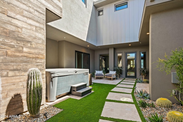 back of house featuring a hot tub, a yard, and a patio area