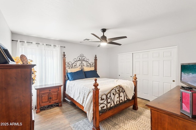 bedroom with ceiling fan, light hardwood / wood-style floors, and a closet