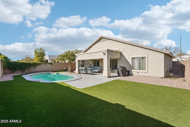 back of property with a yard, a patio area, and a fenced in pool