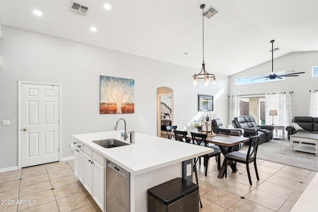 kitchen featuring light tile patterned floors, white cabinetry, an island with sink, dishwasher, and sink