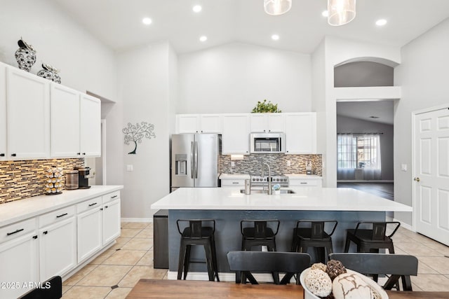 kitchen featuring sink, appliances with stainless steel finishes, an island with sink, a breakfast bar area, and white cabinets