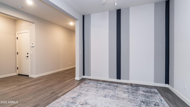 unfurnished room with baseboards and wood finished floors