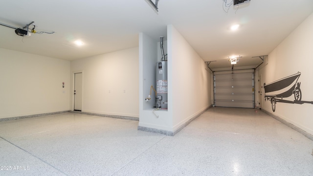 garage featuring baseboards, a garage door opener, and water heater